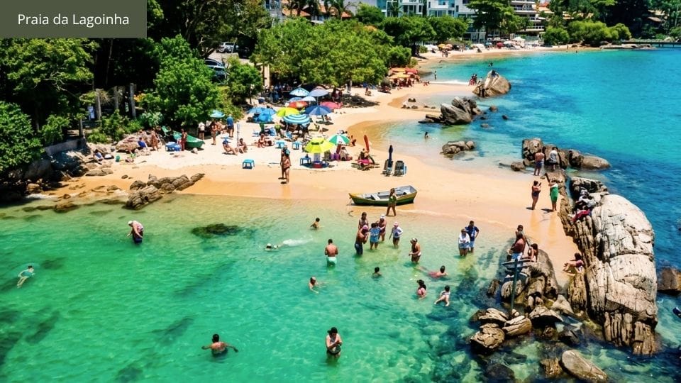 Praia da Lagoinha com água cristalina repleta de peixinhos, visitantes fazendo snorkel.