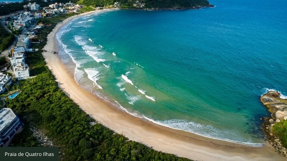 Praia de Quatro Ilhas com água cristalina espelhada em dia calmo de Bombinhas.