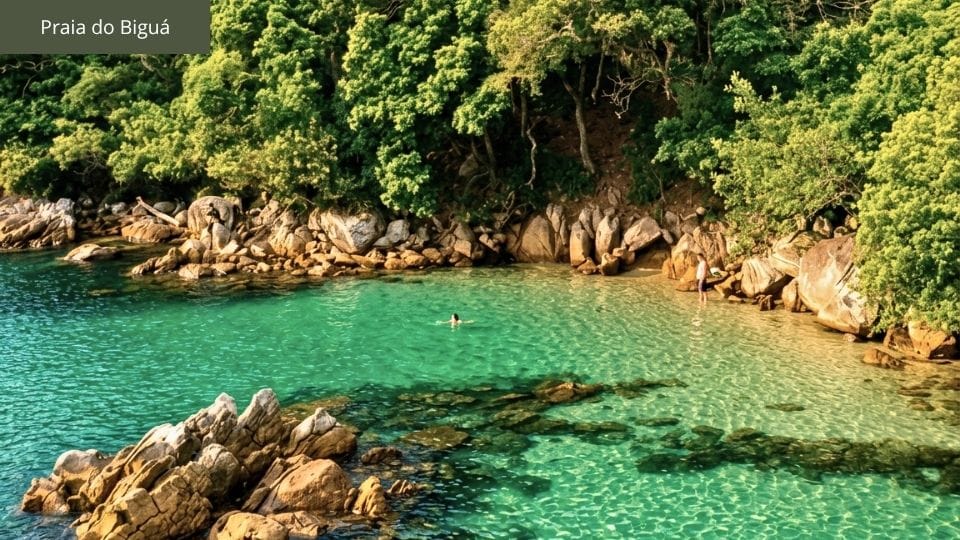 Praia do Biguá com piscina natural entre rochas e pequena faixa de areia.