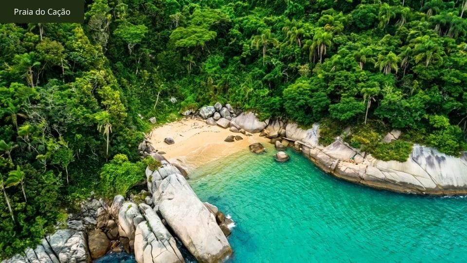Praia do Cação com trampolim de rocha natural e água cristalina, acessada por mar.