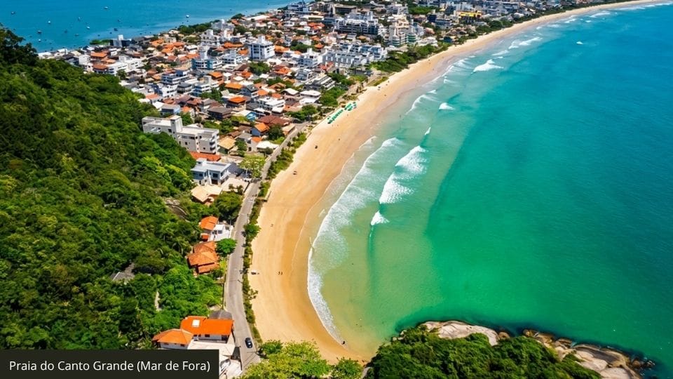 Canto Grande Mar de Fora com água cristalina, praia ampla e restaurante ao fundo.
