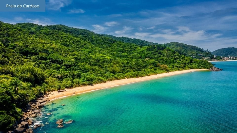 Praia selvagem com areia e costão rochoso, cercada de vegetação nativa, onde crescem pés de goiaba na Costeira dos Zimbros.