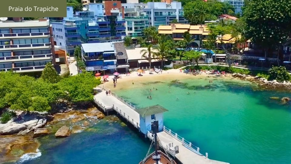 Praia do Trapiche com barcos ancorados e água cristalina de Bombinhas.